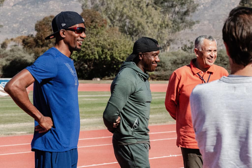 Lex Gillette, Jerome Avery and Sunil Narang standing on a track at a Gold Medal Leadership Experience delivery.